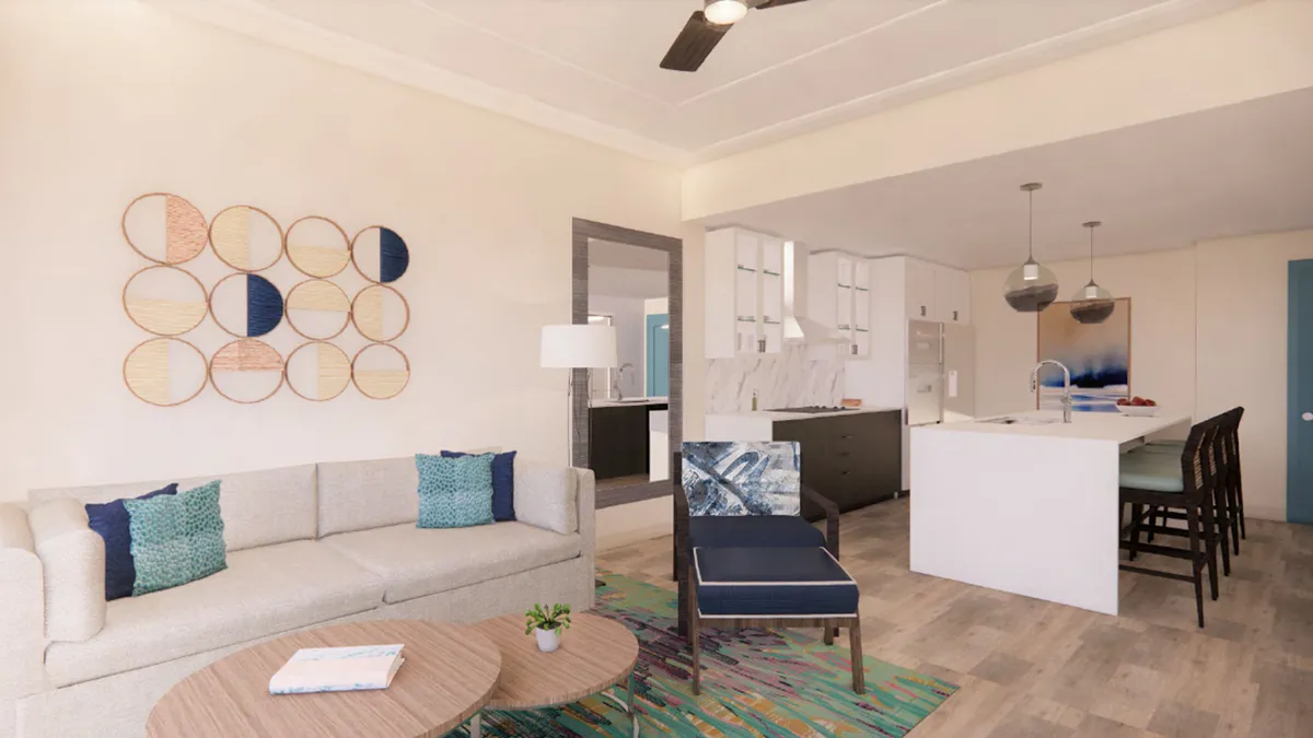 The image showcases a bright, contemporary open-concept living space featuring a plush sofa, stylish coffee table, vivid wall art, and a modern kitchen island with bar stools. The layout invites guests to relax, socialize, and enjoy meals together, setting the scene for both cozy evenings and lively gatherings.